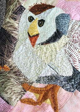 Close-up of a white chicken on a quilt