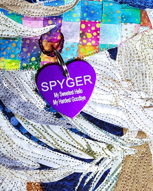 The front of Spyger's purple heart dog tag reading 'My Sweetest Hello, My Hardest Goodbye'